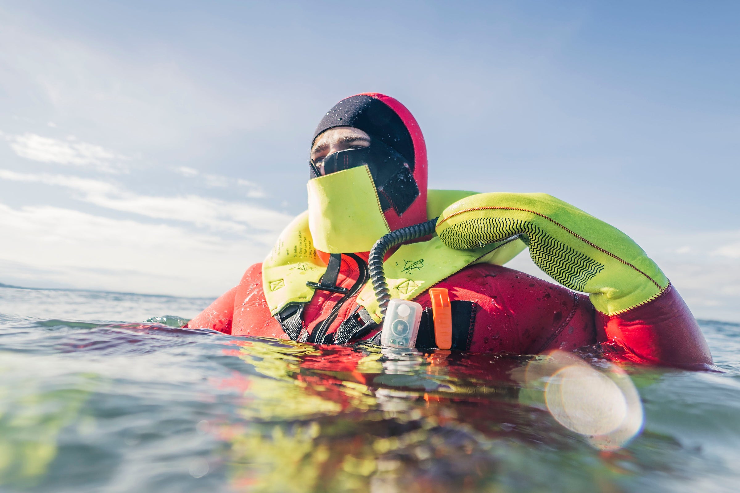 Man in the ocean floating in a Hi-Vis Immersion suit from Kent Safety Products while waiting for Rescue.