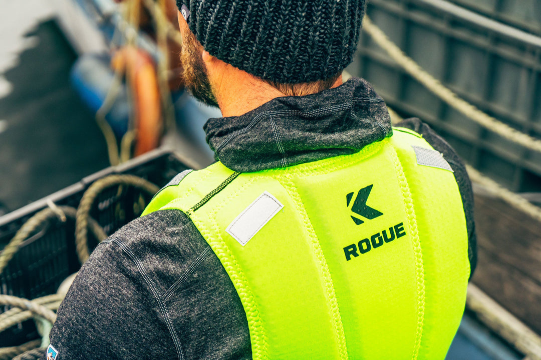 A view of the back of a worker wearing a Hi-Vis Kent Safety Products yellow Life Vest looking down off a boat deck. 
