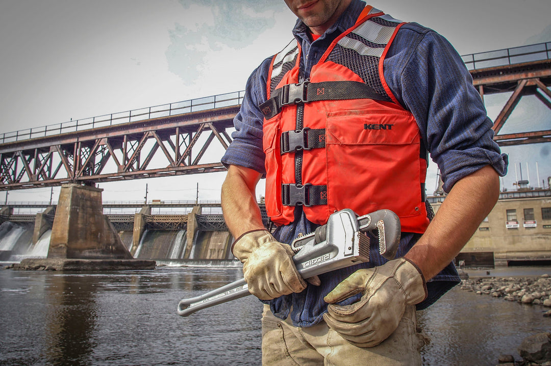 A worker near a Dam wearing a red and black work Life Vest  from Kent Safety Products.