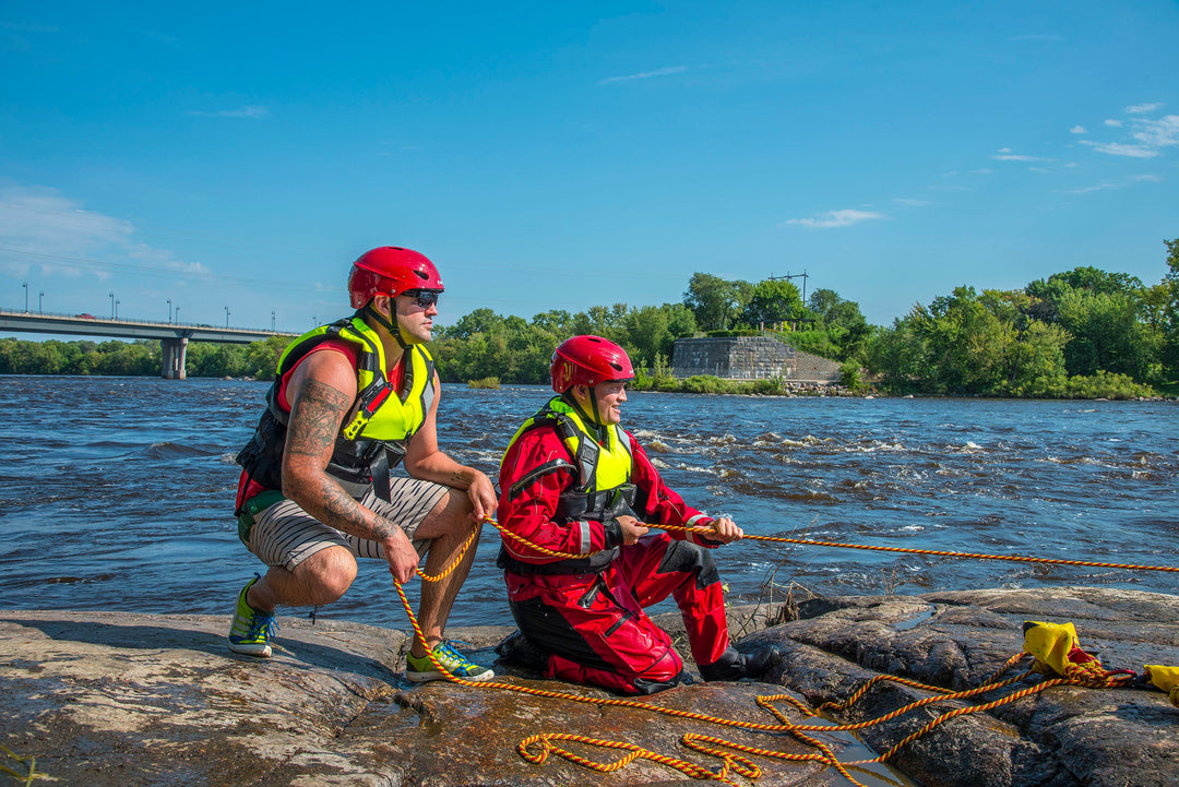 Two Rescue workers on the side of a river wearing Kent Safety Products Bight Green Inflatable Life Vests 