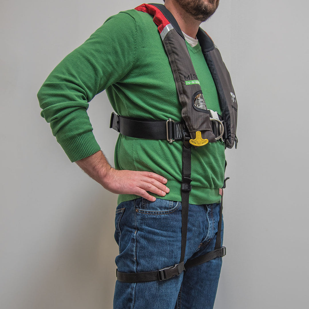 Person in a green sweater wearing Universal Thigh Straps and a life jacket harness.